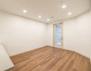 A room with wooden flooring and a white door.