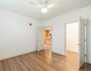 A room with a white wall and a wooden floor.
