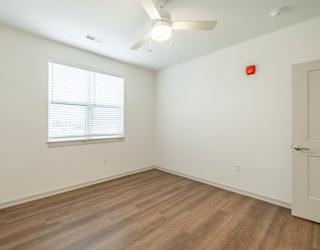 A room with a window and a ceiling fan.