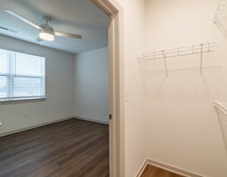 A room with a fan and a window with blinds.