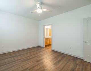 A room with wooden flooring and a ceiling fan.