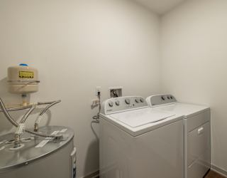 A washing machine is sitting in a small room.