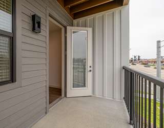 A grey house with a white door and a window.