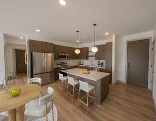 Kitchen and dining area in the CC3 two bedroom plus den, two bathroom floor plan at The Mera in St. Louis Park, Minnesota