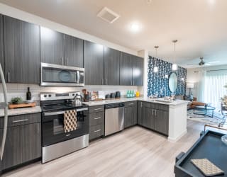 a kitchen with stainless steel appliances and a blue and white patterned wall paper