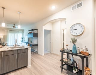 a kitchen and living room with a large clock on the wall