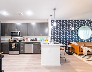 a kitchen and living room with gray cabinets and a blue and white patterned wall