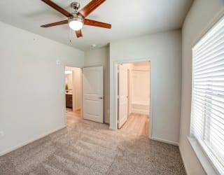 a bedroom with a ceiling fan and a doorway to a bathroom at Avery Ranch, Austin, 78717
