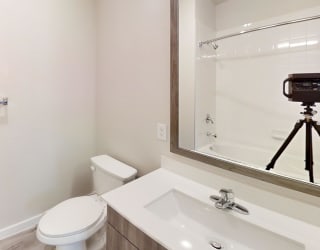 a bathroom with a toilet and a sink and a mirror