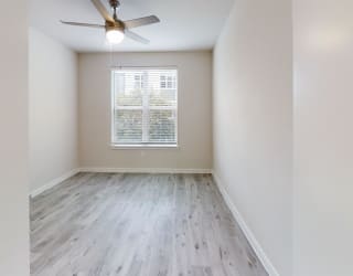 an empty room with hardwood floors and a ceiling fan