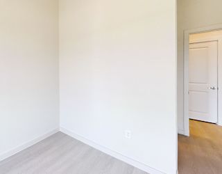 A room with a white door and a light switch on the wall.