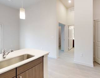 A white kitchen with a sink and cabinets.