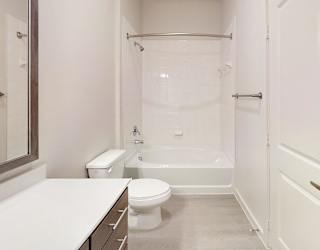 A white bathroom with a toilet, sink, and bathtub.