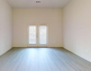 A room with a white door and a window with blinds.