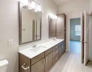 A bathroom with a white sink and a mirror above it.