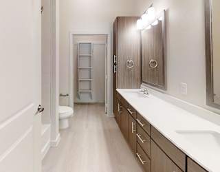 A bathroom with a toilet, sink, and mirror.