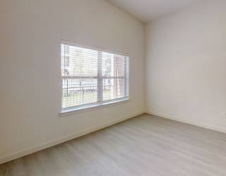 A room with a window and wooden flooring.