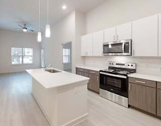 A modern kitchen with a white island and stainless steel appliances.