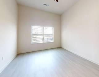 A room with a window and a ceiling fan.