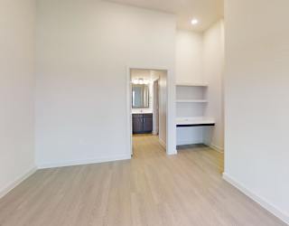 A room with a white wall and a wooden floor.