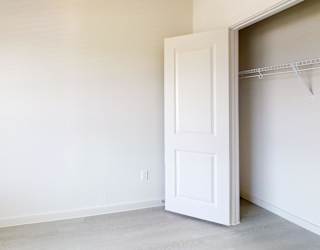 A white door is open in a room with white walls.