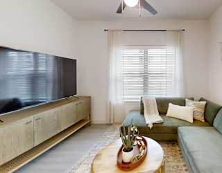 A living room with a green couch and a wooden coffee table.