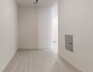 A room with a white wall and a door on the right side.