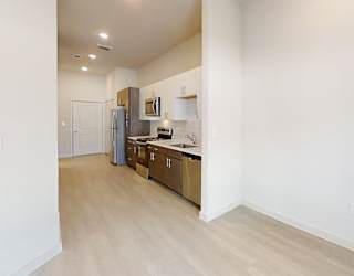 A kitchen with white cabinets and a refrigerator.