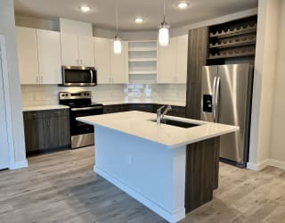 a kitchen with white cabinets and a large island