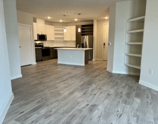 a kitchen and living room with a wooden floor