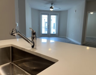 a kitchen with a sink and a ceiling fan