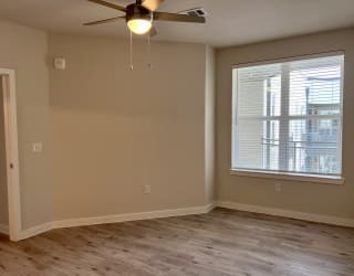 an empty room with a ceiling fan and a window