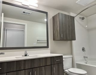 a bathroom with a toilet sink mirror and bathtub