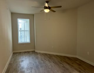 an empty room with a ceiling fan and a window