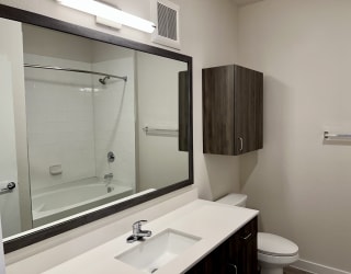 a bathroom with a toilet sink mirror and shower
