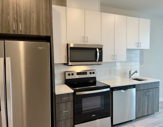 a kitchen with white cabinets and stainless steel appliances