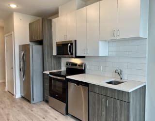 a kitchen with white countertops and stainless steel appliances