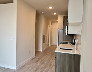 a bedroom with a medium sized bathroom and a kitchen