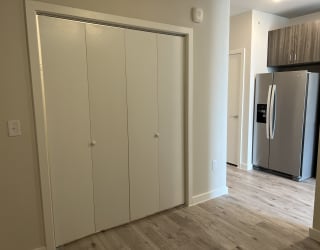 a bedroom with a large closet and a refrigerator