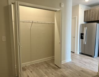 a bedroom with a large closet and a refrigerator