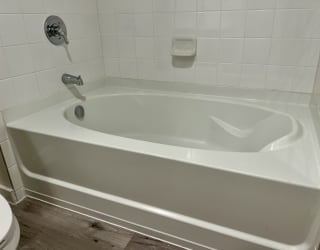 a white bathtub in a white bathroom