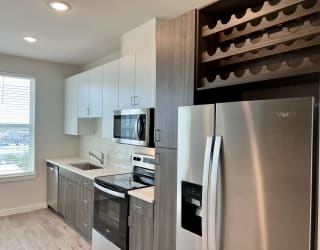 a kitchen with white cabinets and stainless steel appliances