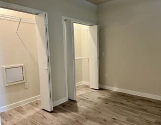 a bedroom with hardwood floors and grey walls