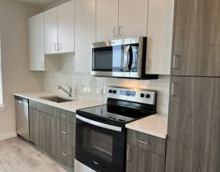 a kitchen with white cabinets and black appliances