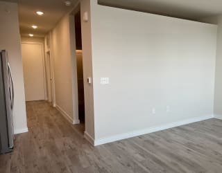 a bedroom with a medium sized bed and a refrigerator in a room