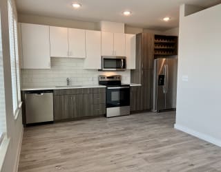 a kitchen with white cabinets and black and white appliances