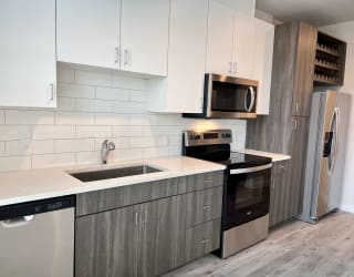 a kitchen with white cabinets and stainless steel appliances