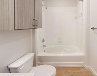 A white bathroom with a toilet, sink, and bathtub.