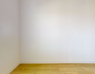 A room with a wooden floor and white walls.