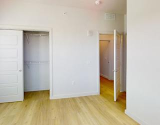 A white door is open to a room with wooden floors.